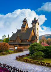 Medieval Norwegian stave wooden church Vang or Wang in summer and Snezka mountain in the background. Church was transferred from Vang in Norway to Karpacz in 1842. Karpacz, Poland