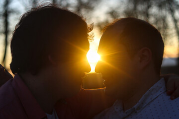 Silhouette of faces of couple of gay men looking at each other with the sunset light in the middle....