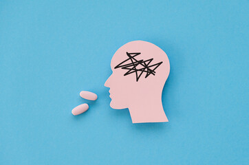 Mental health medication concept image with paper figurine of a head taking an antidepressant pill...