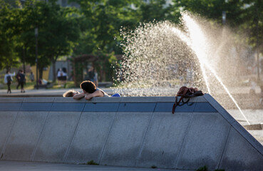 View of the tourists relaxing in the park by the fountain