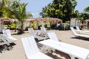 Charlestown, St Kitts and Nevis - March 28, 2028: Beach chairs, palapas and hammocks outside of the port town of Charlestown in Saint Kitts and Nevis
