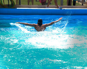Young athlete swimming butterfly style in a pool of blue water