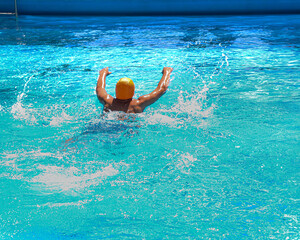 young sportsman swimming breaststroke in a pool of blue water