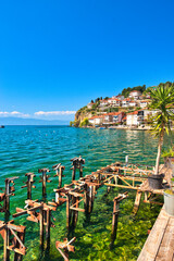 Lake Ohrid, North Macedonia, April 13 2024. Mountain range and peninsula in distance. Ohrid Lake, Macedonia, Europe. The clear mesmerizing waters of lake Ohrid with a beautiful view.   - obrazy, fototapety, plakaty