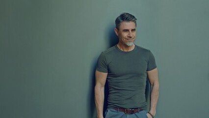 Portrait of a smiling middle-aged man. Happy, confident mid adult male in casual. Blank copy space on a gray wall background. - 783930198