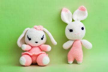 Handcrafted amigurumi rabbit toys displayed on vibrant green backdrop.