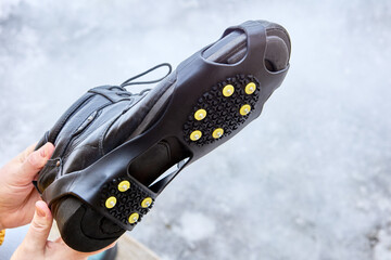 Anti slip studded galoshes worn over sole of shoes to prevent slipping and provide better traction.