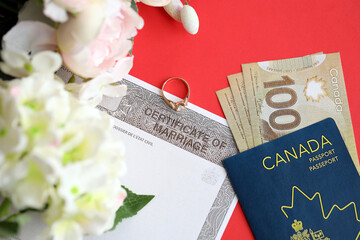 Naklejka premium Canadian Certificate of marriage document and wedding ring with canadian dollars and passport close up