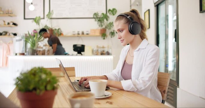 Restaurant, remote work and woman on laptop with headphones for research, website and internet. Freelancer, business and person with cappuccino drink in coffee shop working online and typing email