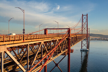 Side view of the 25 de Abril bridge towards Almada-Lisboa with the Tagus River on the right and the...