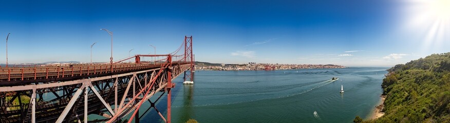 Side view of the 25 de Abril bridge towards Almada-Lisboa with the Tagus River on the right and the...