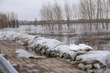 Stacks of sandbags are laid out on the sidewalk to protect against flooding.