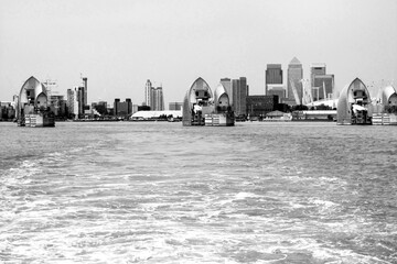 View in black and White over the water towards the futuristic looking Thames Barrier, with the high...