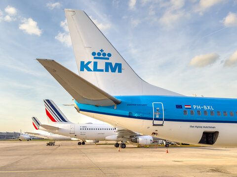 Parked Boeing and Airbus aircraft of blue KLM Royal Dutch Airlines and white Air France at Paris Charles de Gaulle airport on apron or tarmac next to each other, April 12, 2024