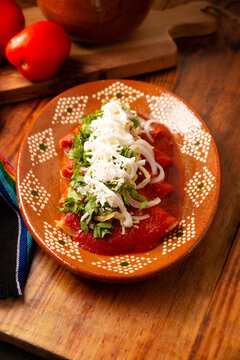 Entomatadas. Also known as Enjitomatadas, a typical dish of Mexican cuisine prepared with corn tortilla, tomato sauce and stuffed with shredded chicken meat. Classic homemade recipe.