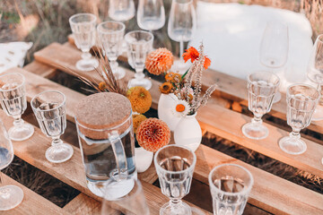 Wooden table with glassware arranged for picnic
