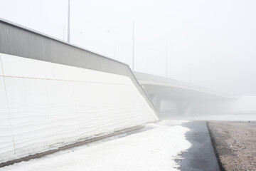 concrete bridge in heavy fog in early spring