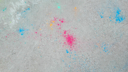 After the celebration of Holi, scattered paints on the asphalt