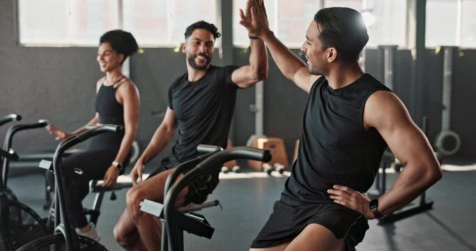 Friends, workout and gym together with high five for fitness, training and exercise to build muscle on arms or legs. People, crosstrainer or cycling bike for cardiovascular strength and determination