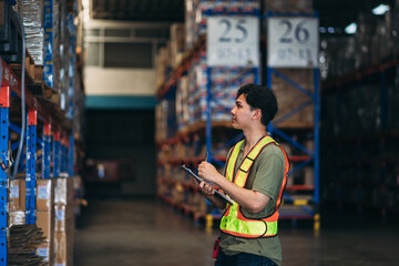 Warehouse worker working and checking the stock in the warehouse. .Factory manager using digital...