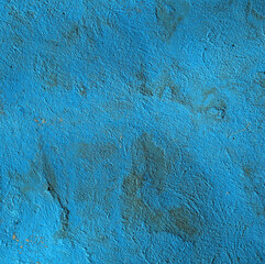 Blue wall, texture, background. Blue, shady backdrop and wall, painted with water-based paint. Uneven and shady surface in blue color. Surface with stains of dirt and shadow from a third-party object - obrazy, fototapety, plakaty