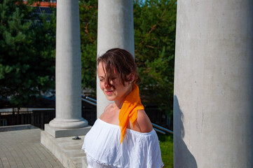 Woman in white romantic dress at Greek or Roman column with colonnade. Summer vacation. Travel...