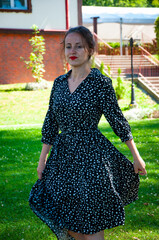 Woman in summer dress dancing on the green grass. Romantic girl dance on lawn. Carefree woman in...