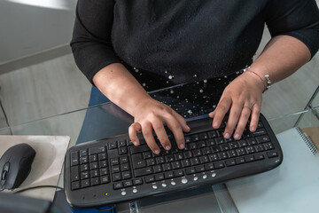 A woman is typing on a keyboard