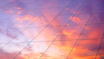 Web banner Modern glass architecture with reflection of red and blue sunset sky. Dramatic bright...