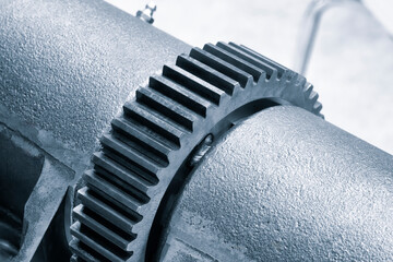 A close up of a gear with a lot of detail. The gear is silver and has a lot of teeth