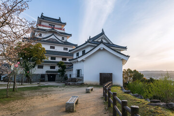 Karatsu castle with white sakura and city view at sunset, Saga