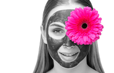 Portrait of attractive girl with healthy clean skin and beautiful make-up. She applied the mask to her face. Aesthetic cosmetology and makeup concept.Near her face is a pink flower