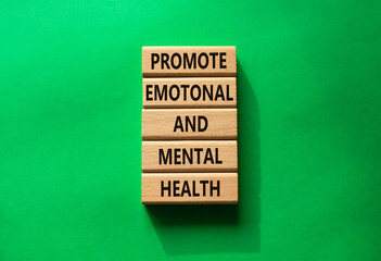 Health symbol. Wooden blocks with words Promote Emotional and Mental Health. Beautiful green...