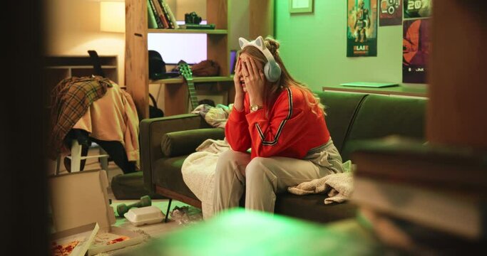 Gamer, stress and lose with competition, esports and frustrated or mistake. Woman, rage and technology with neon, lounge and apartment or home living room with console and fail for video game play