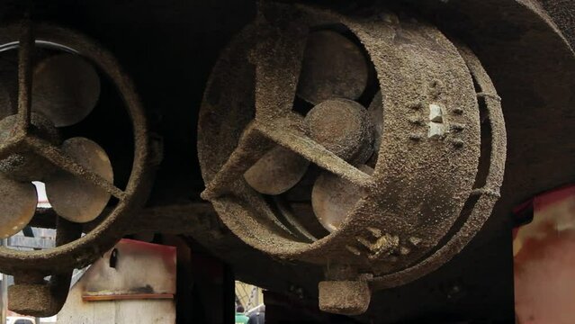 Corroded ship propellers await refurbishment in dry dock. Marine repair, vessel maintenance process captured, showcasing rust-eaten blades, maritime industry maintenance at shipyard.