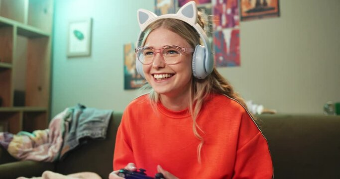 Woman, controller or play in gaming, success or excited to celebrate achievement or level up on sofa. Gen z, female gamer or yay in winning, remote or internet video game by solving, how to or ux
