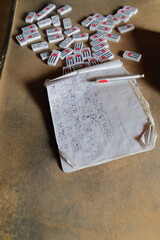 Double nine style domino tiles -Cuban flag on the reverse- scattered over the table, and the notebook with the results of the game. Viñales-Cuba-171