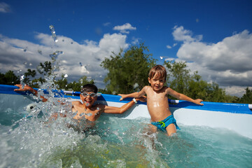 Happy siblings enjoying their time in a domestic swimming pool - 784029965