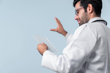 Back view of smart doctor looking application form while standing at white background. Professional...