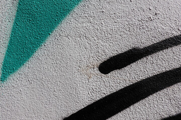 Abstract wall surface with part of graffiti. Geometric black and green lines, on white grunge wall background
