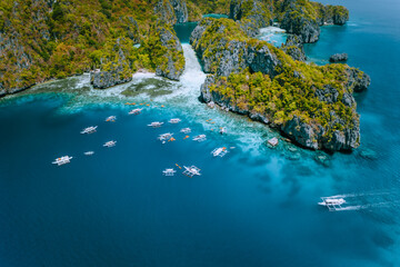 Aerial view of amazing Mililoc Island. Tourist boats near big Lagoon. El Nido, Palawan,...