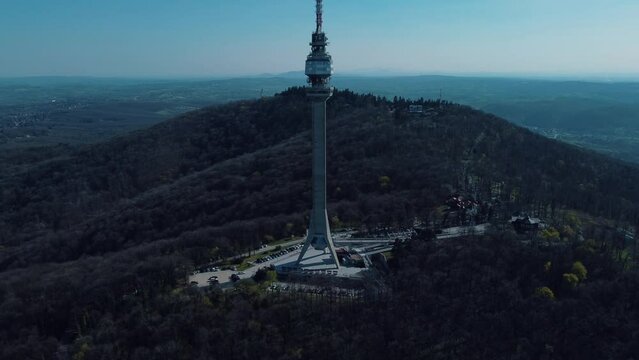 Majestic tall radio tower in Avala, Belgrade, Serbia under the clear blue sky pointing in the clouds