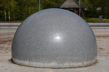 Gray granite ball in the city park
