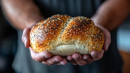   A tight shot of a hand holding a slice of bread, studded with sesame seeds