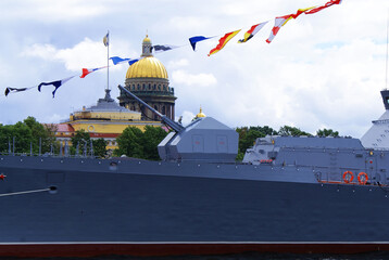 Warship moored on the embankment in the city center, navy, military weapons.