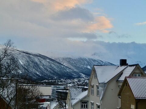 Colors of sunrise punctuate this view of Tromso at the foot of the Tromsdalstinden mountain in northern Norway.