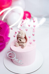 The birthday cake is decorated with a hare figurine. first birthday cake