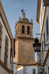 The bell tower of a church seen from a street in the historic center of Cordoba, Andalusia, Spain.