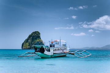 Tourism divers boat in blue cadlao lagoon on island hopping tour, El Nido, Palawan, Philippines