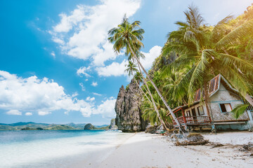 Vacation holiday on Palawan - El Nido island hopping tour. Lonely deserted hut under palm trees,...